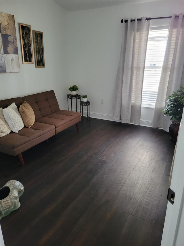 living room featuring baseboards and dark wood-style flooring