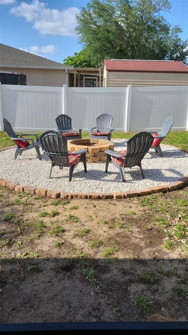 view of yard featuring a patio area, a fire pit, and fence