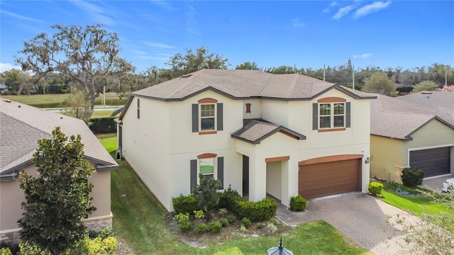 view of front of home featuring a garage, decorative driveway, roof with shingles, and stucco siding