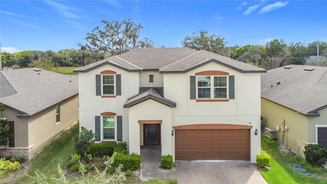 view of front of home with roof with shingles, an attached garage, decorative driveway, a front lawn, and stucco siding