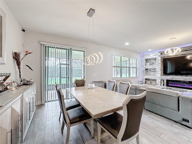 dining room featuring a textured ceiling, plenty of natural light, light wood-style flooring, and recessed lighting