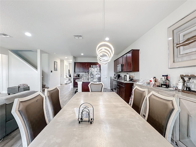 dining area featuring light wood-style floors, stairs, visible vents, and recessed lighting