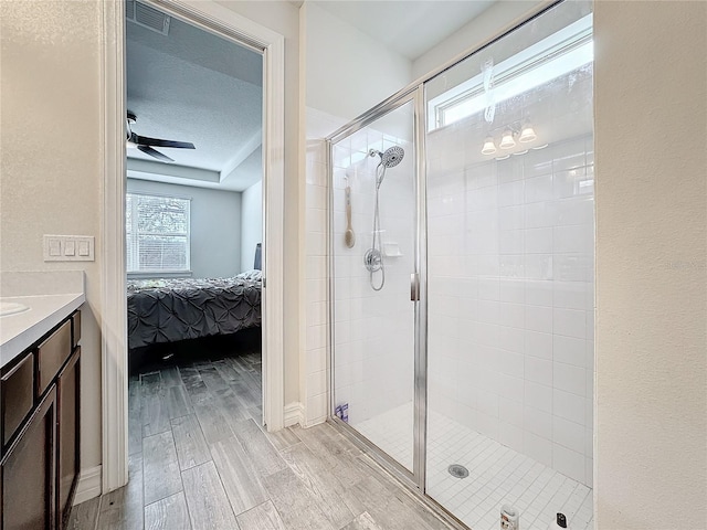 ensuite bathroom with a textured ceiling, a stall shower, ensuite bath, and wood tiled floor