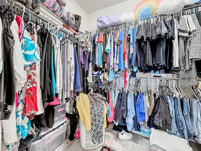 spacious closet featuring vaulted ceiling and wood finished floors