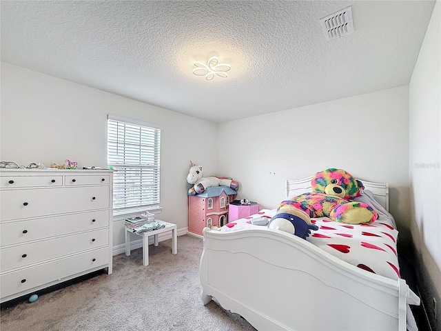 bedroom featuring baseboards, visible vents, a textured ceiling, and light colored carpet