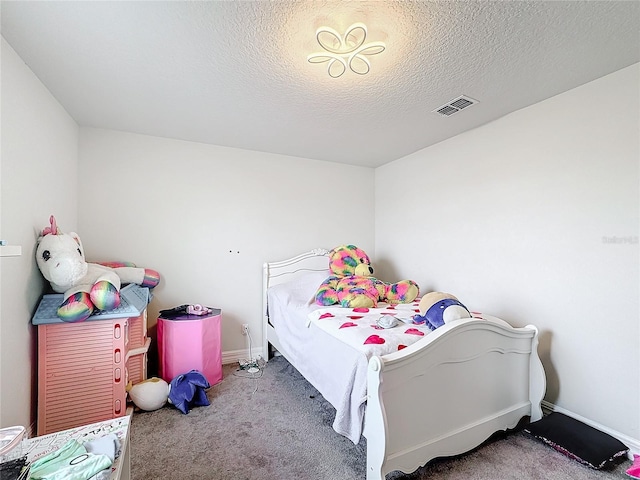 carpeted bedroom featuring visible vents, a textured ceiling, and baseboards