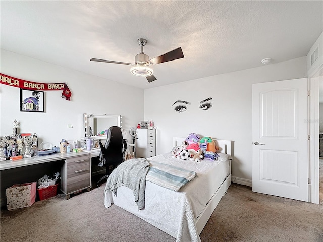 bedroom featuring carpet, visible vents, ceiling fan, and a textured ceiling