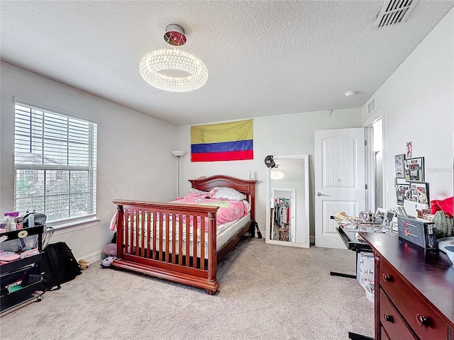 bedroom featuring visible vents, a textured ceiling, and light colored carpet