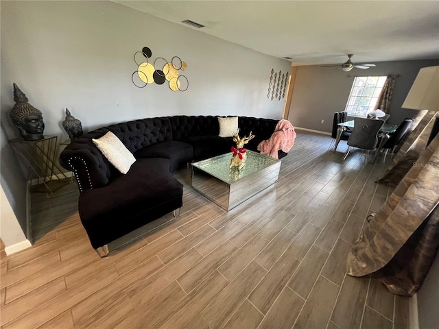 living area featuring visible vents, a ceiling fan, and wood finish floors