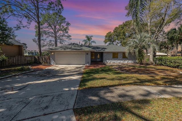 view of front of house with french doors, fence, a garage, driveway, and a front lawn