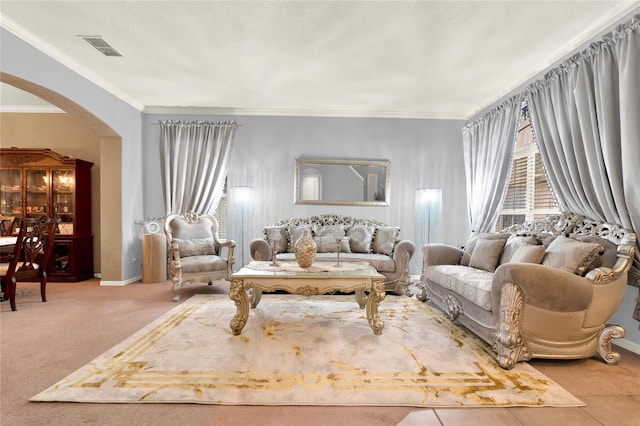 living area with arched walkways, baseboards, visible vents, and crown molding