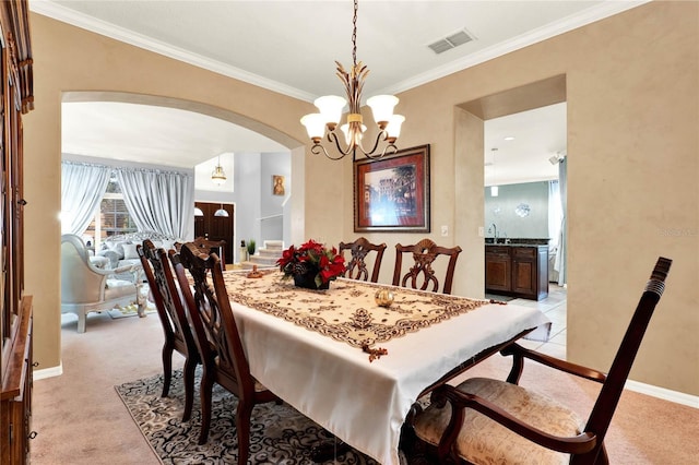 dining area with arched walkways, light carpet, visible vents, and crown molding