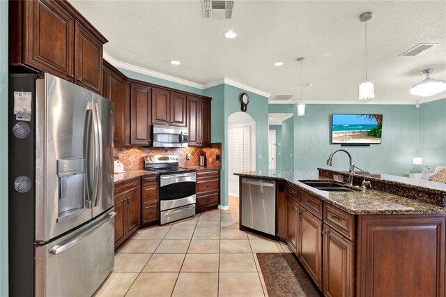 kitchen with appliances with stainless steel finishes, a sink, visible vents, and pendant lighting