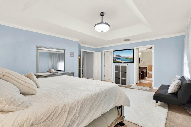 carpeted bedroom featuring a raised ceiling, visible vents, ornamental molding, connected bathroom, and baseboards