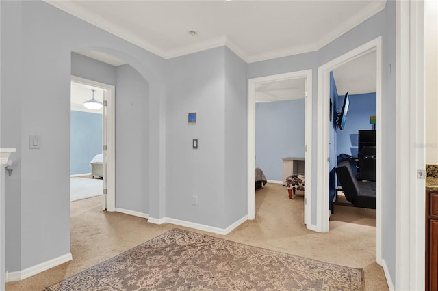 hallway with light carpet, arched walkways, and baseboards