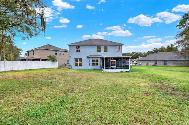 back of house featuring a sunroom, fence, stucco siding, and a yard