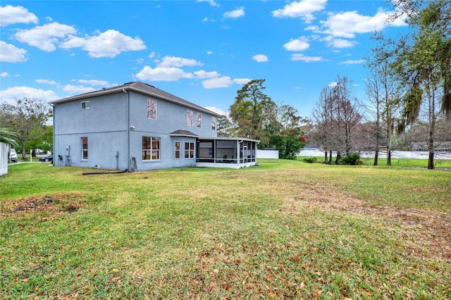 rear view of property with a sunroom and a yard