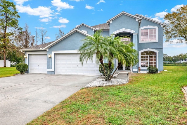 view of front facade with a garage, a front lawn, concrete driveway, and stucco siding