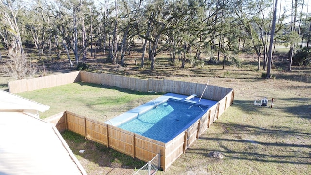 view of swimming pool featuring a lawn and fence