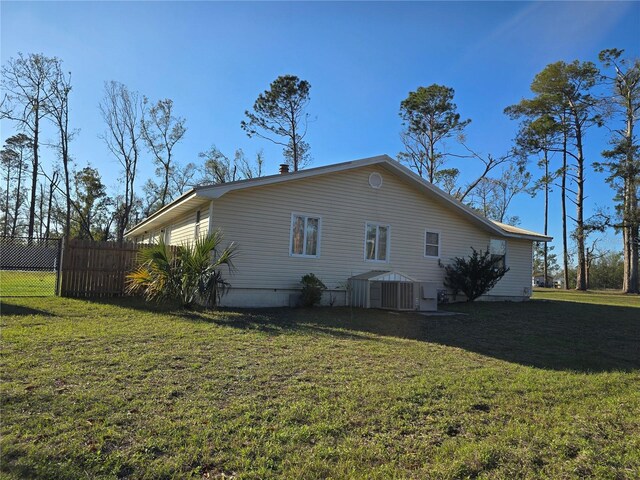 view of side of home featuring a yard and fence