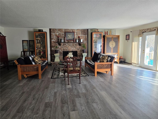 living area featuring a textured ceiling, a fireplace, and wood finished floors