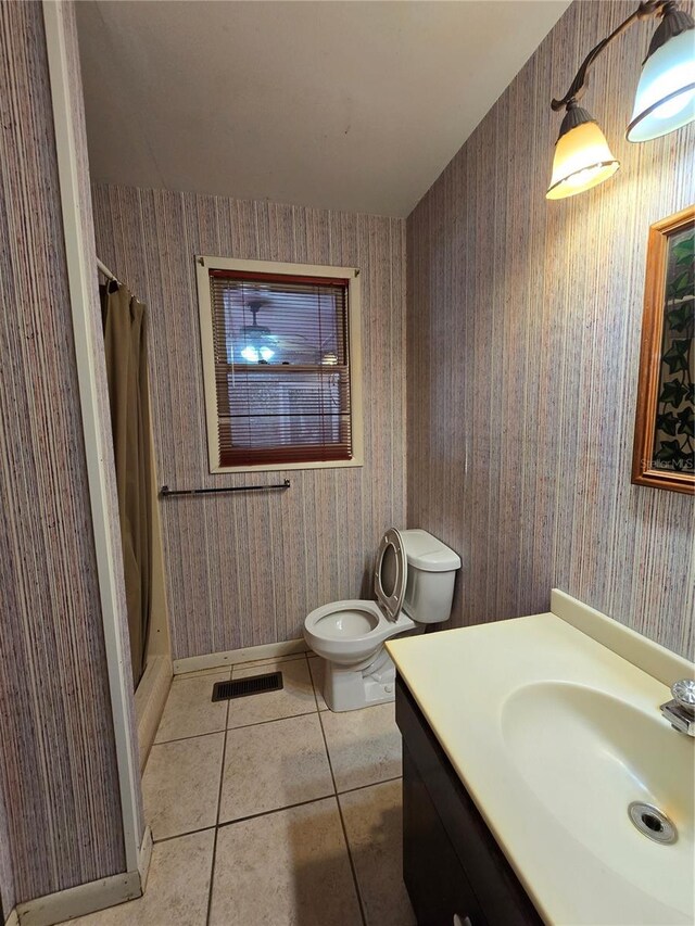 bathroom featuring tile patterned flooring, toilet, vanity, a shower with curtain, and wallpapered walls