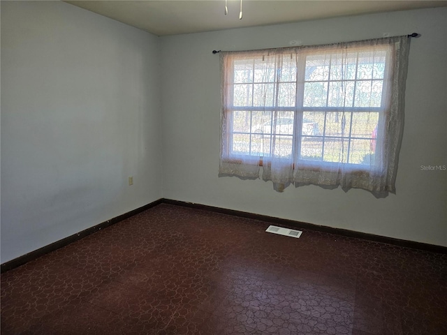 spare room with baseboards and visible vents