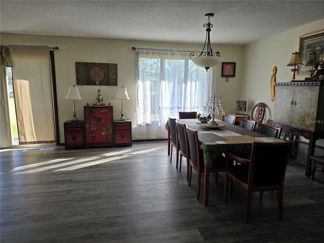 dining room with a textured ceiling and wood finished floors