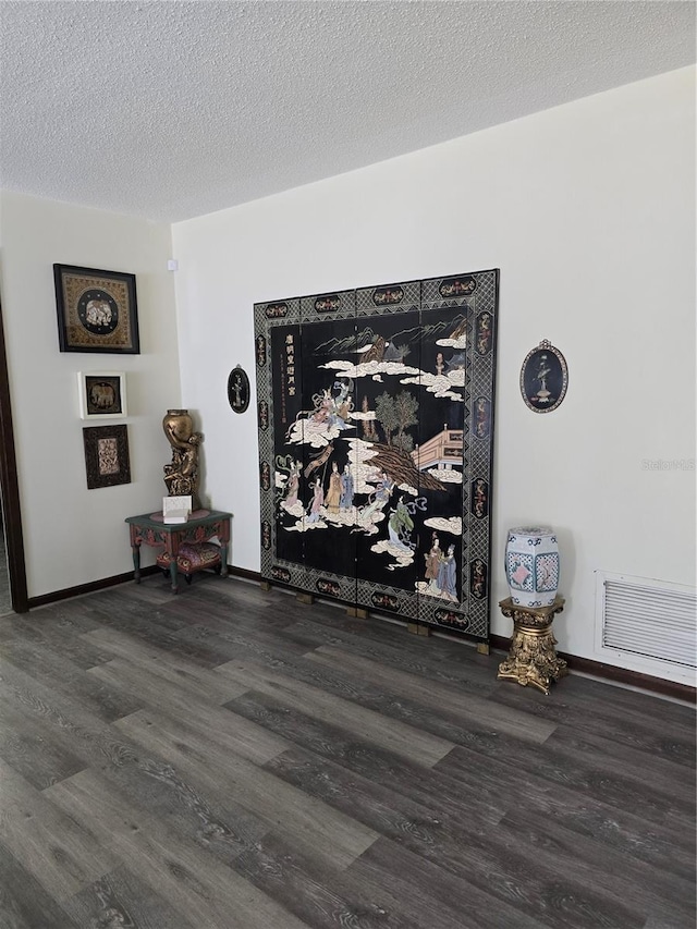 room details with baseboards, a textured ceiling, visible vents, and wood finished floors