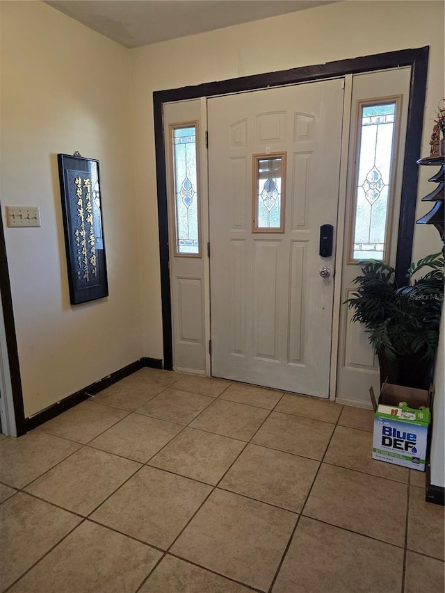 entrance foyer featuring light tile patterned flooring and baseboards