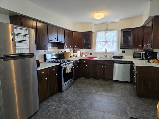 kitchen featuring stainless steel appliances, light countertops, dark brown cabinets, and decorative backsplash