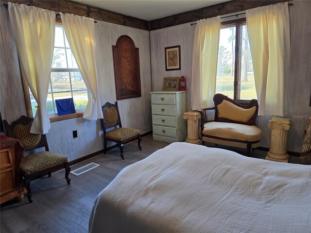 bedroom featuring multiple windows, wood finished floors, visible vents, and baseboards