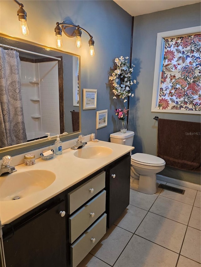 bathroom with curtained shower, tile patterned flooring, a sink, and visible vents