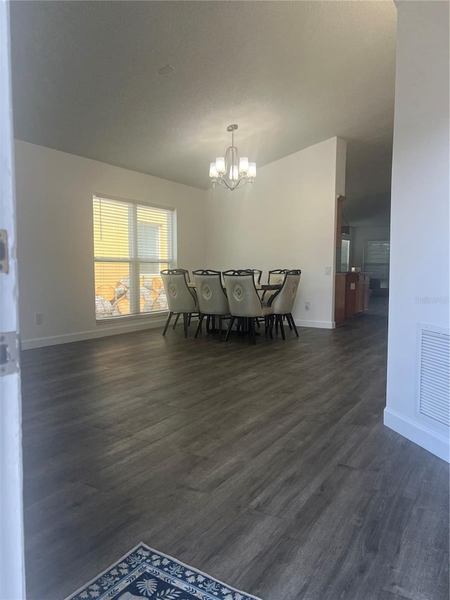 dining room with dark wood-type flooring, visible vents, a notable chandelier, and baseboards