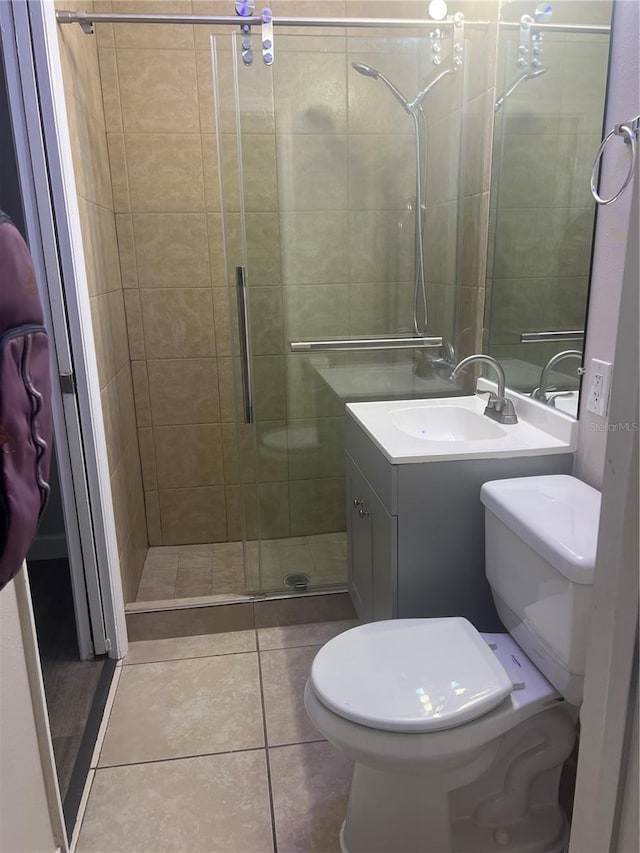 bathroom featuring a stall shower, tile patterned flooring, vanity, and toilet