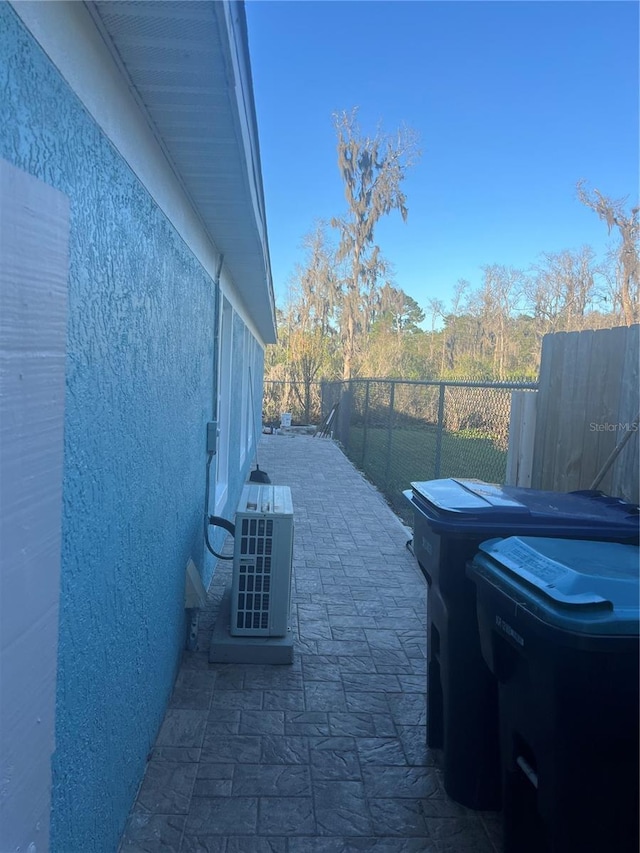 view of home's exterior with fence, a patio, and stucco siding