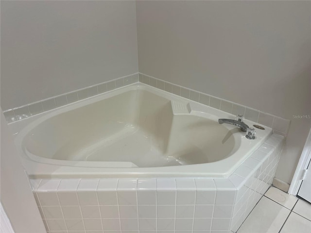 bathroom with a garden tub and tile patterned flooring