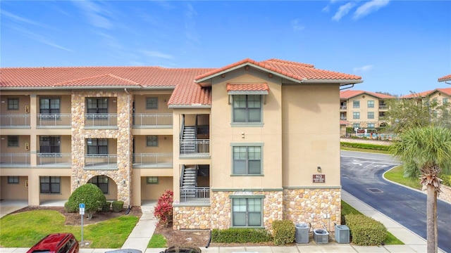 view of property featuring uncovered parking and central AC