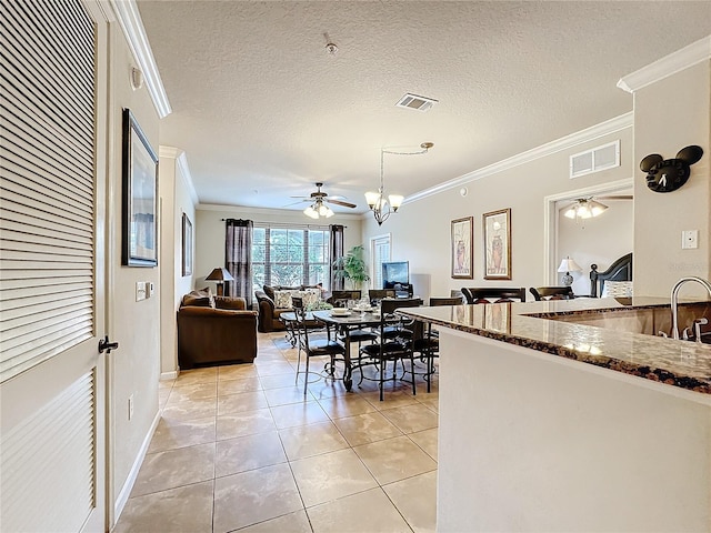 dining room featuring visible vents, crown molding, a textured ceiling, and light tile patterned flooring