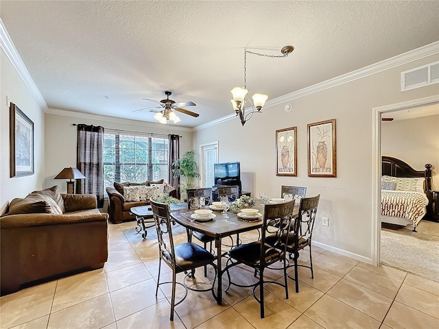 dining room with light tile patterned floors, a textured ceiling, visible vents, and crown molding