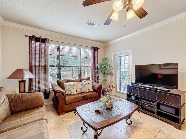 living area featuring a textured ceiling, light tile patterned flooring, visible vents, and crown molding