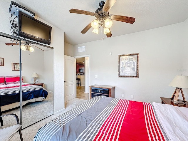 bedroom with light carpet, visible vents, baseboards, a ceiling fan, and a closet