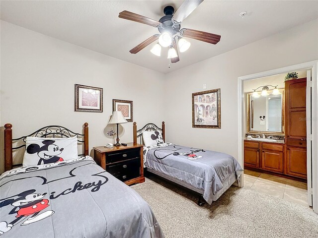 bedroom featuring light tile patterned floors, ceiling fan, and connected bathroom