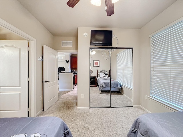 bedroom featuring a ceiling fan, multiple windows, visible vents, and a closet