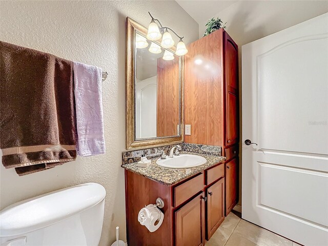 bathroom featuring toilet, tile patterned flooring, and vanity