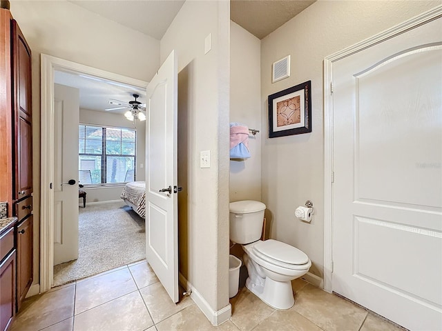 bathroom with baseboards, visible vents, toilet, and tile patterned floors