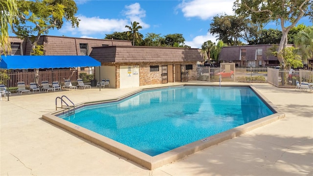 pool with fence and a patio