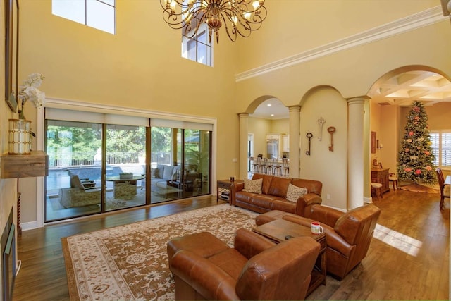 5719 Emerson Pointe Way, Orlando, FL 32819 - living area featuring decorative columns, arched walkways, dark wood finished floors, and a chandelier