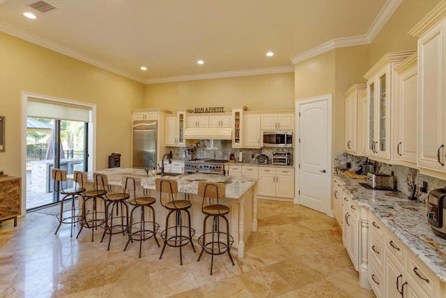 5719 Emerson Pointe Way, Orlando, FL 32819 - kitchen with glass insert cabinets, a large island with sink, high end appliances, and a kitchen bar
