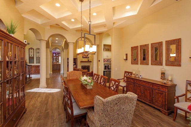 5719 Emerson Pointe Way, Orlando, FL 32819 - dining area with a high ceiling, ornate columns, dark wood-style floors, and arched walkways